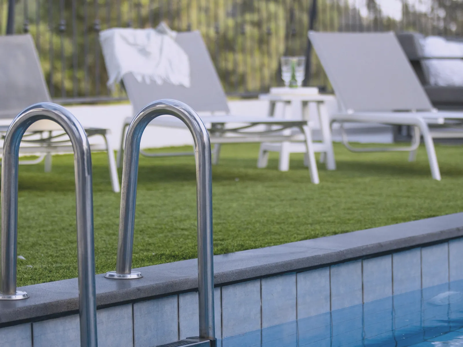 Pool ladder and lounge chairs on a lawn