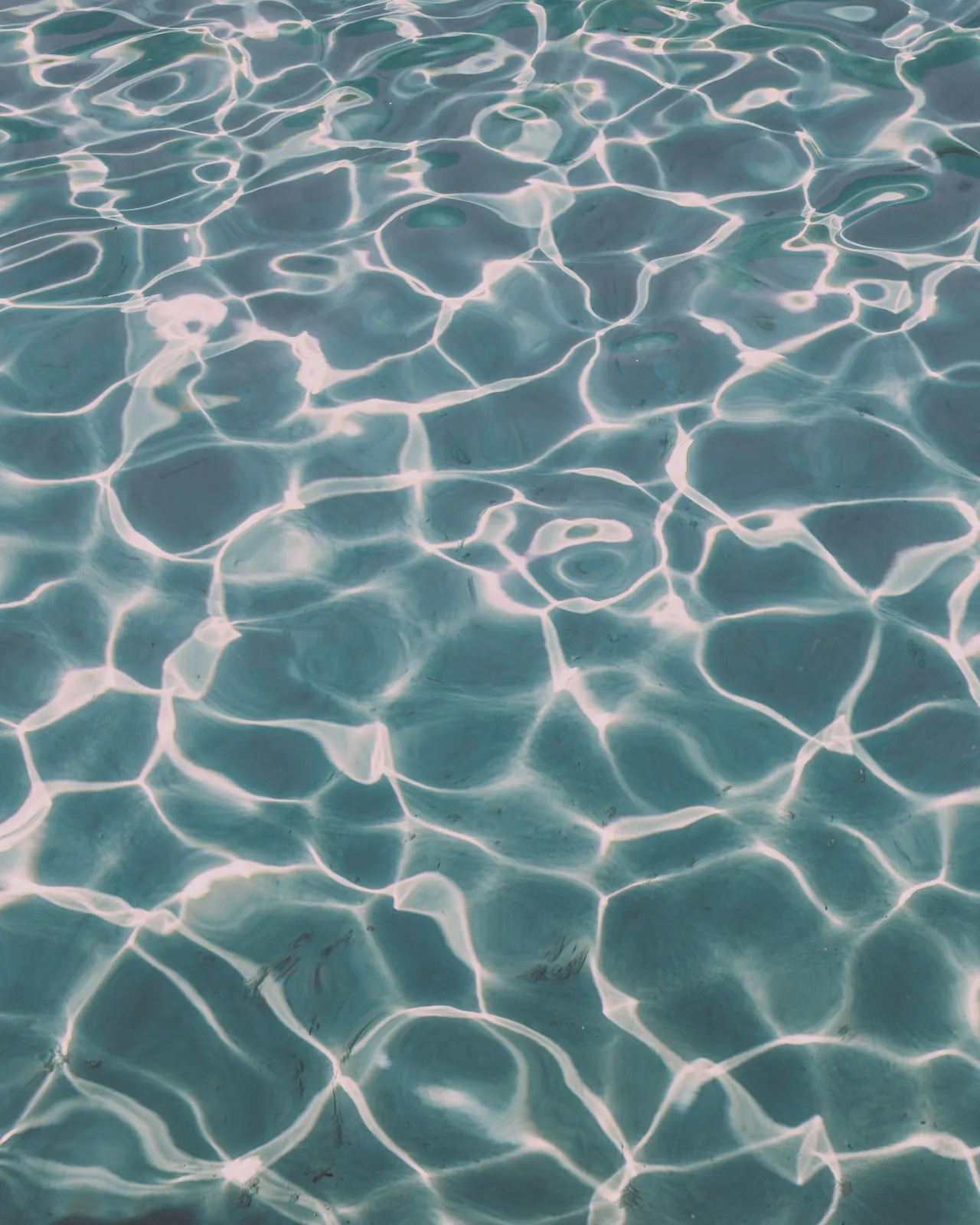 Sunlight rippling on clear pool water